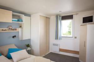モニーガにあるCamping Piantelleのソファと窓が備わる小さな客室です。