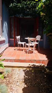 two chairs and a table on a brick patio at Central Garden Room Tamboerskloof in Cape Town