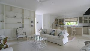 uma sala de estar com um sofá e uma mesa em Villa Blanc em Beau Vallon