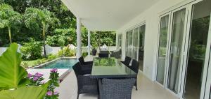 a patio with a table and chairs next to a pool at Villa Blanc - Chateau Elysium in Beau Vallon
