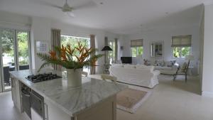 a kitchen and living room with a couch and a table at Villa Blanc in Beau Vallon