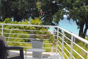 balcón con mesa, sillas y vistas al océano en Villa Blanc en Beau Vallon