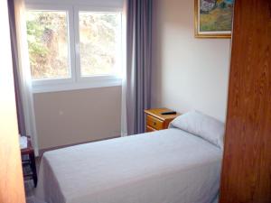 Habitación pequeña con cama y ventana en Pensión Bos en Bergondo