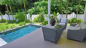 a swimming pool with two chairs and a table at Villa Blanc in Beau Vallon