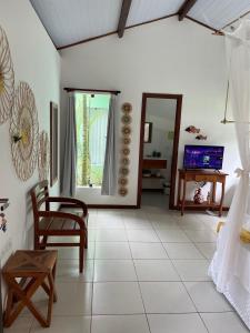 a living room with a table and chairs and a television at Casa Jasmim Imbassaí-BA in Mata de Sao Joao
