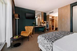 um quarto com uma cama e uma secretária com uma cadeira em Hotel Ózon & Luxury Villas em Mátraháza