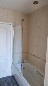 a bathroom with a bath tub with a shower at Spacious Victorian Double Room 3 in Balby