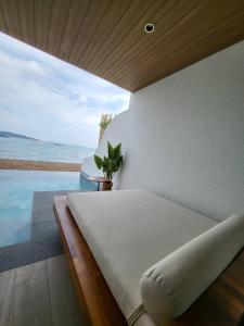 a bedroom with a bed and a view of the ocean at Tasana bar and luxury resort in Ko Larn