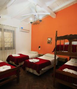 ビアレット・マセにあるComplejo Turistico - Hotel Pinar serrano - Bialet Masse - Cordobaの赤い壁のベッドルーム1室(二段ベッド3組付)