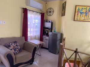 a living room with a couch and a refrigerator at Quiet 2-bed property within the centre of city in Port-of-Spain