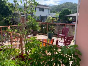 a patio with two chairs and plants on a balcony at Quiet 2-bed property within the centre of city in Port-of-Spain