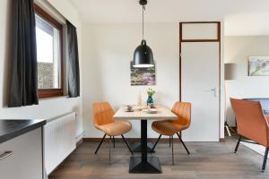 cocina y comedor con mesa y sillas en Summio Vakantiepark Reevallis, en Vijlen