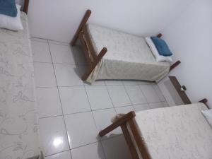 a room with two beds and a tiled floor at Casa para até 8 pessoas em Garanhuns in Garanhuns