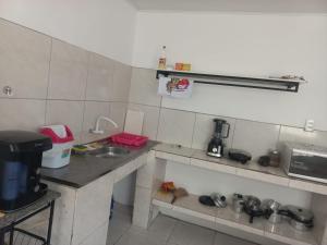 a small kitchen with a sink and a counter at Casa para até 8 pessoas em Garanhuns in Garanhuns
