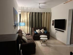a living room with a couch and a tv at Room in Flat with Amazing City and Sea View in Mumbai