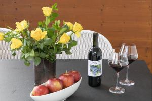 提洛洛的住宿－Schattmair Hof，一张桌子,上面放着玫瑰花瓶和一瓶葡萄酒