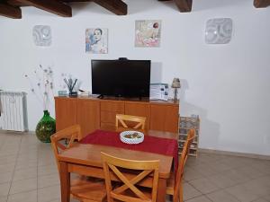 comedor con mesa y TV en Il Vicolo House, en Santa Rufina