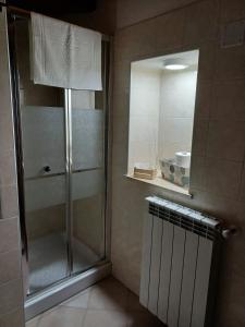 y baño con ducha y puerta de cristal. en Il Vicolo House, en Santa Rufina