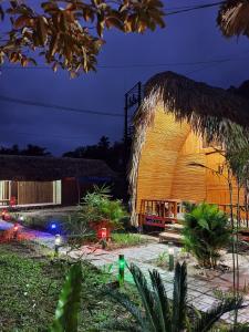 a large building with a thatched roof at night at Homestay Khoáng nóng Thông Nguyên in Nam Giang