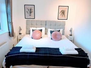 a bedroom with a large bed with pink and blue pillows at Saffron - Heathrow-Airport-with Parking in Feltham