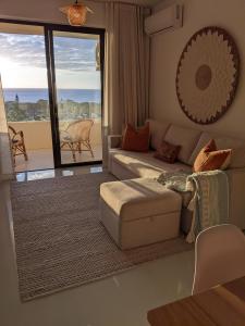 a living room with a couch and a view of the ocean at Seaview serenity apartment in Flic-en-Flac