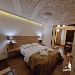 um quarto com uma cama grande e uma cabeceira em madeira em River House Boutique Hotel em Yerevan