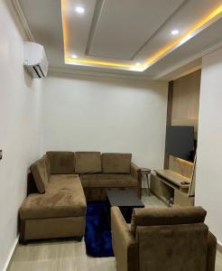 uma sala de estar com um sofá e uma mesa em Eureka Luxury Apartment em Gwarinpa