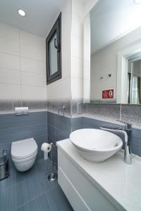 a bathroom with a white sink and a toilet at Maldives Holiday Homes in Kyrenia