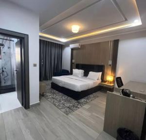 um quarto de hotel com uma cama e uma secretária em Eureka Luxury Apartment em Gwarinpa