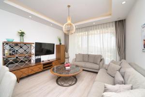 a living room with a couch and a tv and a table at Maldives Holiday Homes in Kyrenia