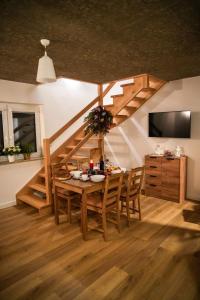 ein Esszimmer mit einem Tisch und einer Treppe in der Unterkunft ZACISZE W MIEŚCIE in Ustrzyki Dolne