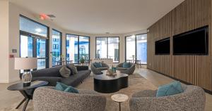 a living room with couches and a flat screen tv at Westshore Apartments by Barsala in Tampa
