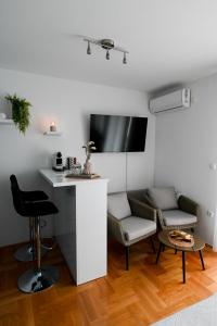 salon z 2 krzesłami i stołem w obiekcie Studio apartman Aurora w mieście Ðakovo