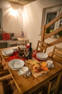 a wooden table with food and wine glasses on it at ZACISZE W MIEŚCIE in Ustrzyki Dolne