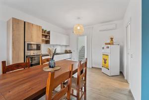 Una cocina y un comedor con una mesa y un refrigerador. en Aria De Domus, en SantʼAntìoco