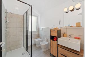Un baño con ducha, lavabo e inodoro. en Aria De Domus, en SantʼAntìoco