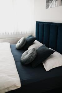 two pillows on a bed with a blue head board at Studio apartman Aurora in Đakovo