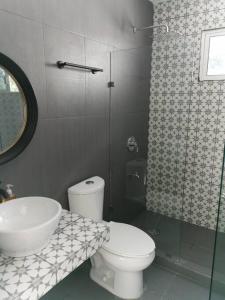 a bathroom with a toilet and a sink and a shower at Residencia Maya con Hermosa Alberca y Jardines in Mérida