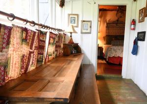 een houten bank in een kamer met een bed bij Country Woods Inn in Glen Rose