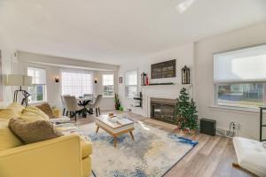 a living room with a yellow couch and a fireplace at Dog-Friendly Rochester Home about 3 Mi to Downtown! in Rochester