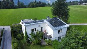 a white house with solar panels on the roof at Gartenstudio Peony in Innsbruck