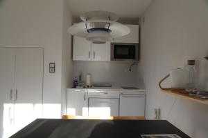 a kitchen with white cabinets and a blue light fixture at Gartenstudio Peony in Innsbruck +3 photos