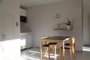 a kitchen with a wooden table and chairs at Gartenstudio Peony in Innsbruck