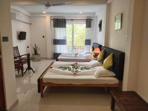 Hotel Sapid Luck Yala Safari في تيساماهاراما: غرفة معيشة بها سريرين وأريكة