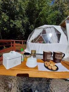 ein Picknicktisch mit einem Zelt und Essen darauf in der Unterkunft Nativa Glamping in Villarrica