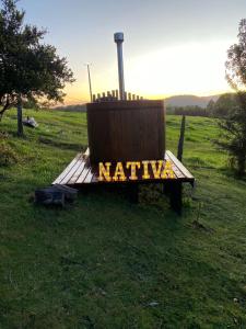 un banco de madera con la palabra Niki escrita en él en Nativa Glamping, en Villarrica