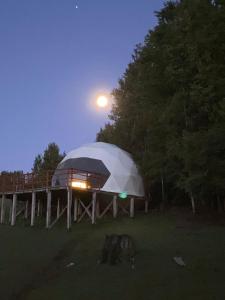 una casa en la cúpula con la luna en el cielo en Nativa Glamping, en Villarrica