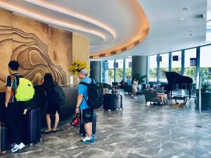 a group of people standing in a lobby with luggage at HD Panorama Nha Trang Condotel- 2 nguyen thi minh khai, nha trang in Nha Trang +42 photos