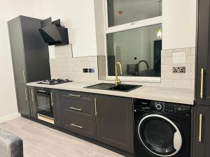 a kitchen with a washing machine and a sink at Newly Refurbished 1Bedroom 4 mins walk to Crystal Palace Station in Crystal Palace