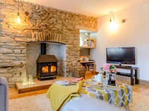 a living room with a stone wall with a fireplace at 2 bed property in Llandysul 77655 in Llangynllo